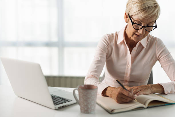 istock Senior  businesswoman taking notes in the office 1321967712