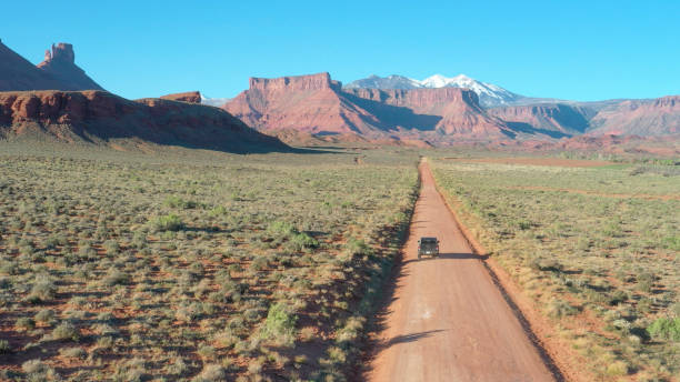 vista aérea del vehículo todo todo el camino que conduce por la carretera del desierto - truck space desert utah fotografías e imágenes de stock