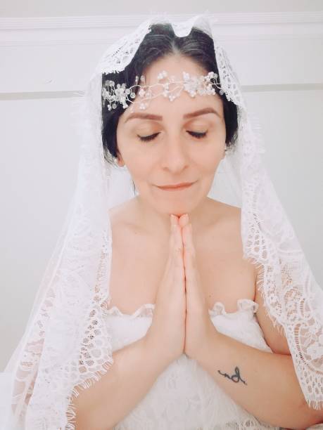 istock beautiful bride girl with plain white veil front of white background. 1321974408