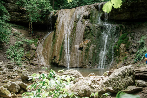 istock Small forest waterfall. jets of water flowing down from boulders 1321978922