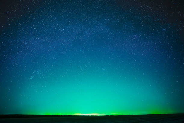 Beautiful Night Sky Glowing Stars Background Backdrop With Colorful Sky Gradient. Colourful Night Starry Sky In Blue Aquamarine Green Colors. Dark Ground. Copy Space.