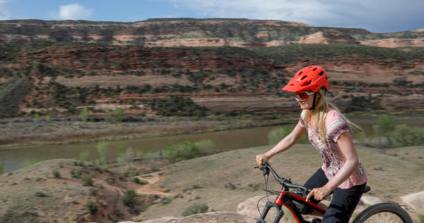istock Young woman mountain bikes along mountain ridge 1321982900