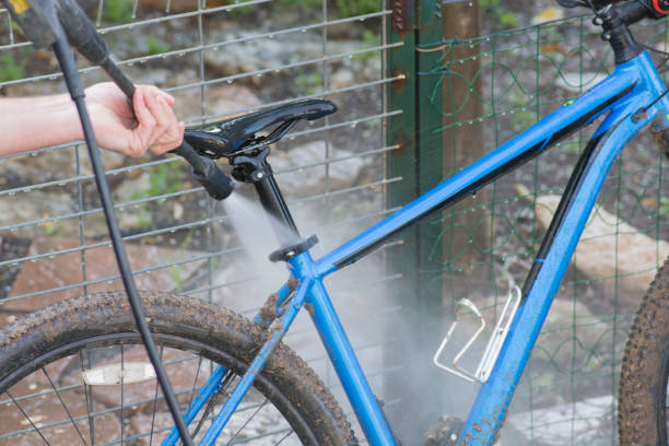 istock Man cleaning blue bicycle using high pressure washer 1321985326