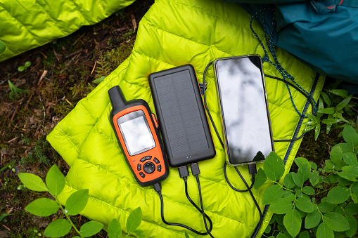 Charging electronic devices with a USB power bank while camping. Battery charging of devices outdoors. Electronic device charging.