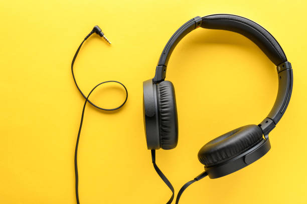 istock Black wired Headphones on yellow background. Entertainment concept 1321990927