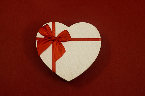 closed heart shaped box isolated on red background. holidays concept