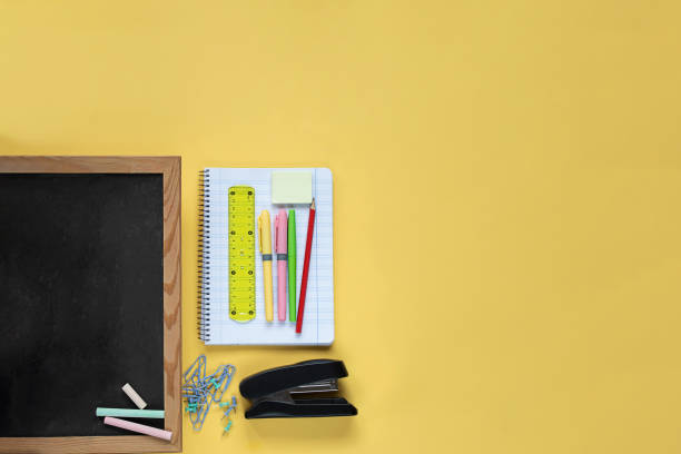 istock School supplies and chalkboard  on bright yellow background 1321999170
