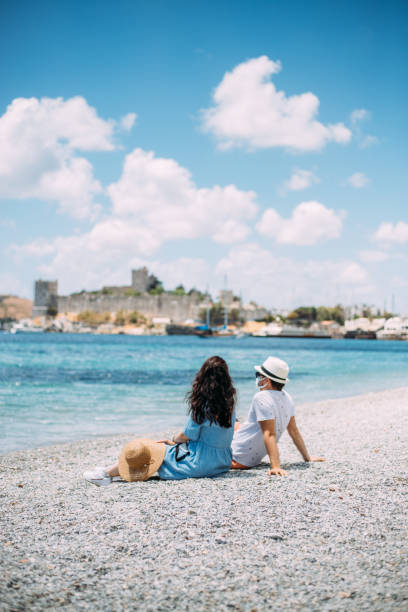 istock Couple with face mask looking to sea 1322003007