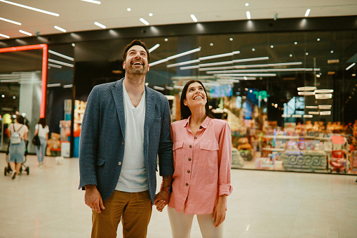 Young couple in the shopping mall, going to the video games arcade, spending the weekend together.