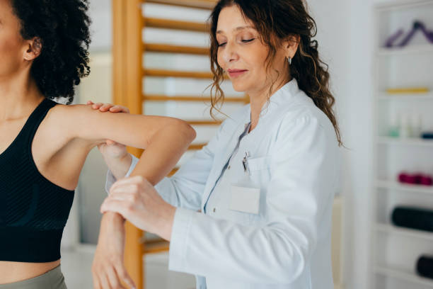 istock Physiotherapist Helping Beautiful African American Woman with Hand Exercise 1322012180