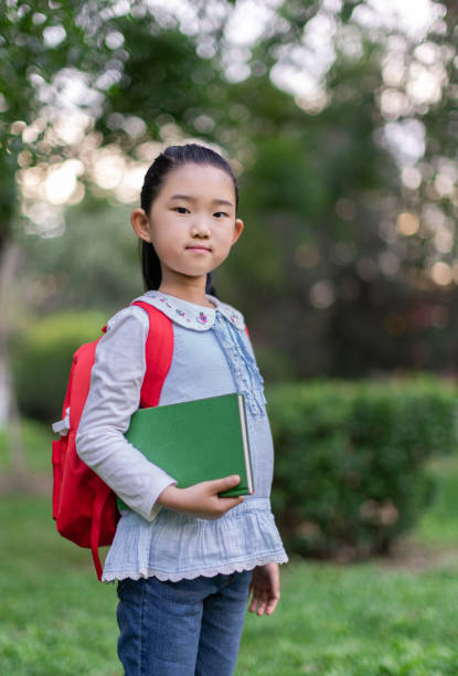 istock Little Girl Holding Book 1322019932