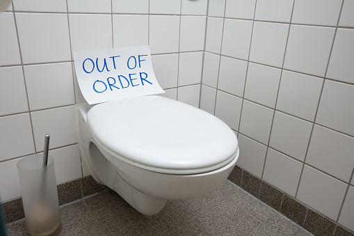 Written Text Out Of Order Message On Paper Over Toilet Bowl In Bathroom