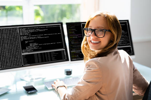 コンピュータ上でのプログラマーの女性のコーディング - プログラマー ストックフォトと画像