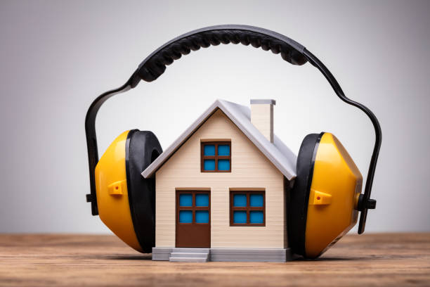 Close-up Of Working Yellow Protective Headphone On The House Model Over The Wooden Table