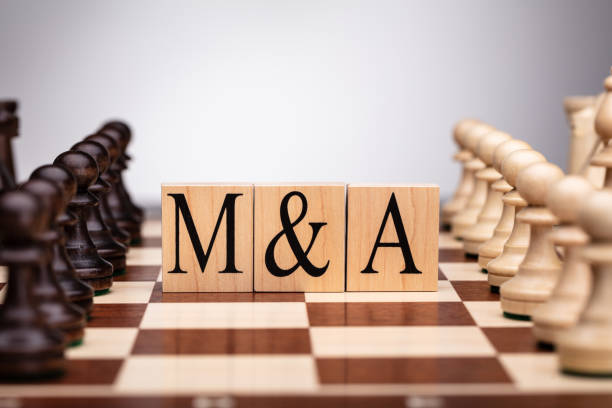 istock Wooden Blocks With Mergers And Acquisitions Text On Chess Board 1322052248