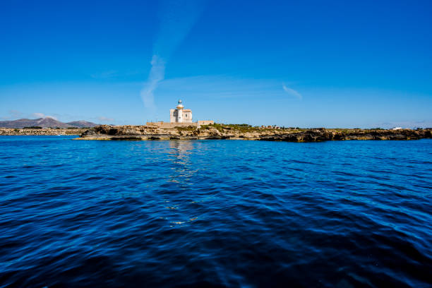 lighthouse on the coast with blue water in the island of Favignana in Trapani Sicily Italy