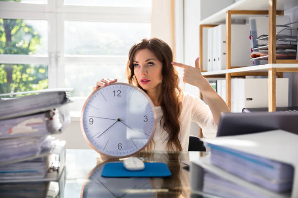 istock Businesswoman With Clock Making Shooting Gesture 1322054862