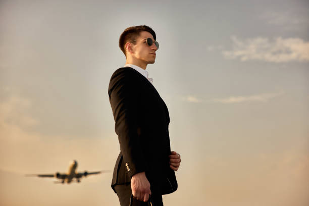 istock Businessman against sky with landing airplane. 1322055021