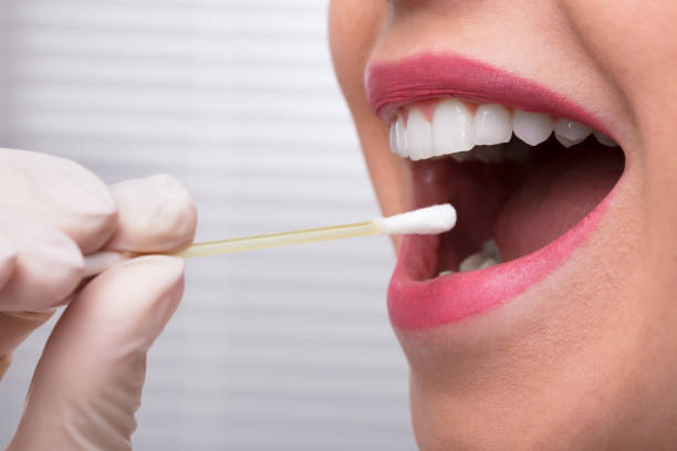 istock Dentist's Hand Taking Saliva Test From Woman's Mouth 1322055063