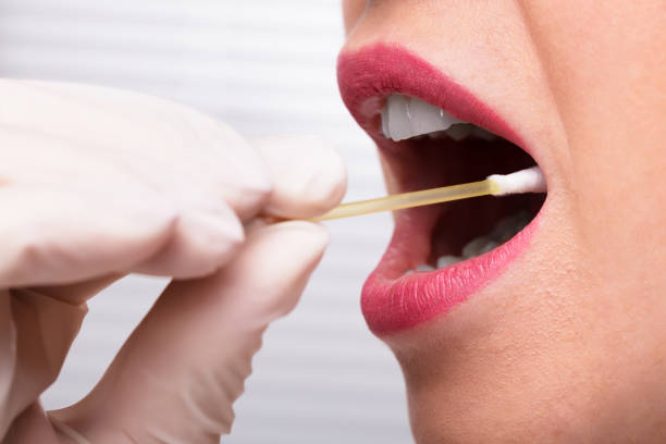 istock Dentist's Hand Taking Saliva Test From Woman's Mouth 1322055067