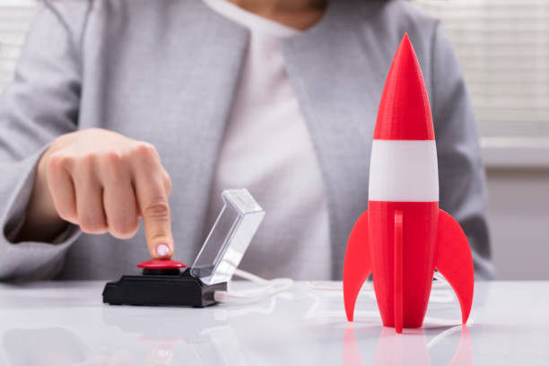 Businesswoman's Hand Launching Rocket Businesswoman's Hand Launching Rocket By Pressing Red Button founder stock pictures, royalty-free photos & images