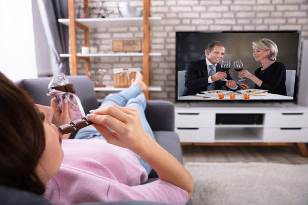 istock Woman Eating Chocolate While Watching Television 1322055905