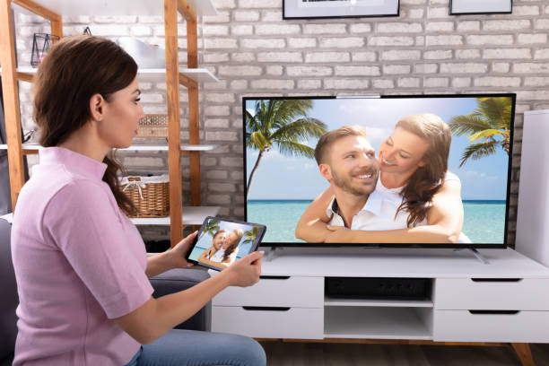 istock Woman Connecting Television Channel Through Digital Tablet 1322055908