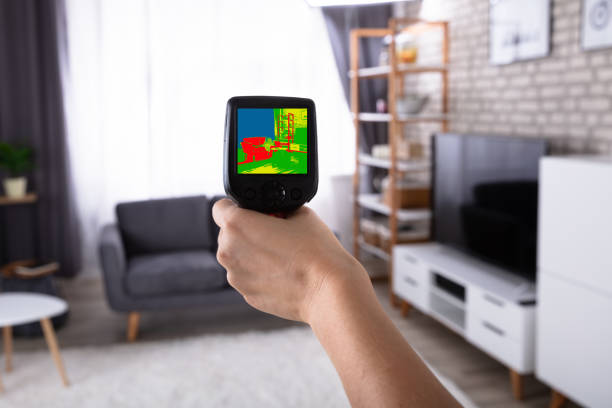 istock Woman Using Infrared Thermal Camera In Living Room 1322056110
