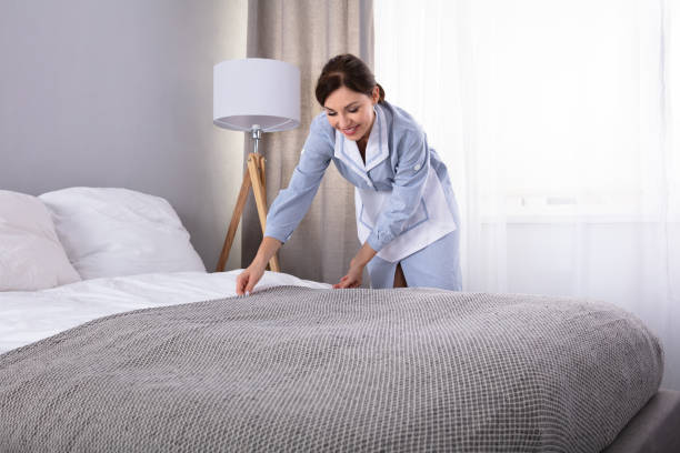 istock Housekeeper Making Bed In Hotel Room 1322056135