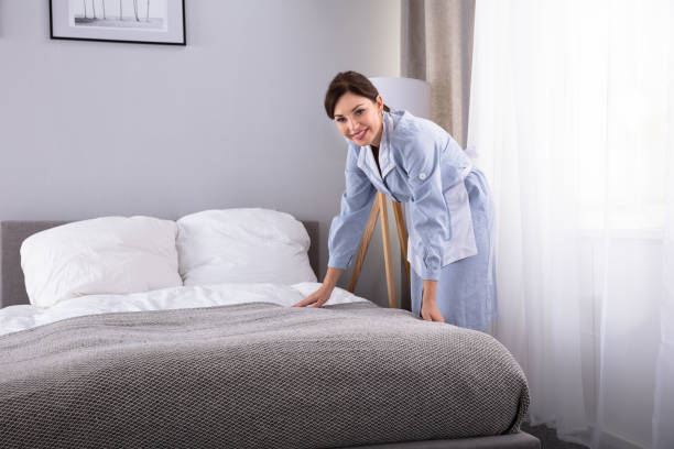 istock Housekeeper Making Bed In Hotel Room 1322056139