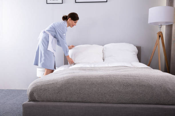 istock Housekeeper Making Bed In Hotel Room 1322056147