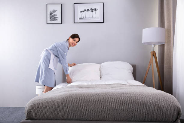 istock Housekeeper Making Bed In Hotel Room 1322056150