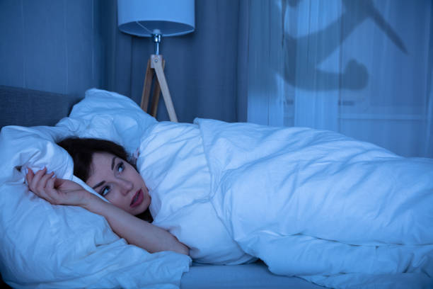 istock Frightened Young Woman Lying On Bed 1322056183