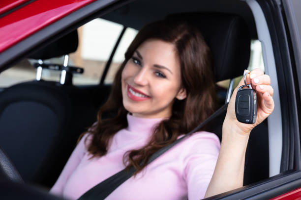 istock Woman Sitting Inside Car Showing Key 1322056308