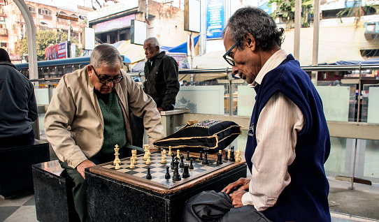 This image was captured in a Chess club in an afternoon, where two elderly persons engrossed in chess playing in a chess club of Kolkata,where the chess lovers came together and enjoy chess playing.