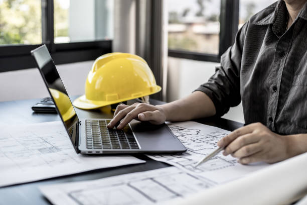 istock Architect engineers are using laptops to check house plans and print them out on paper after designing and presenting them to clients and requesting to modify some of the house plans. Interior Design. 1322061552