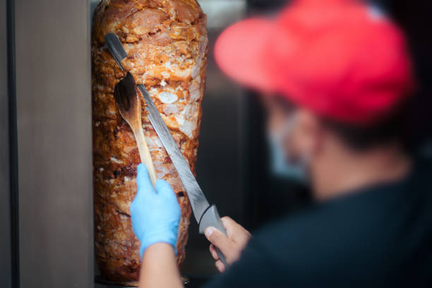 Fast Food Chef Cutting Roasted Meat with Doner Knife Professional cook working in a restaurant roasting chicken for shawarma dish shawarma stock pictures, royalty-free photos & images
