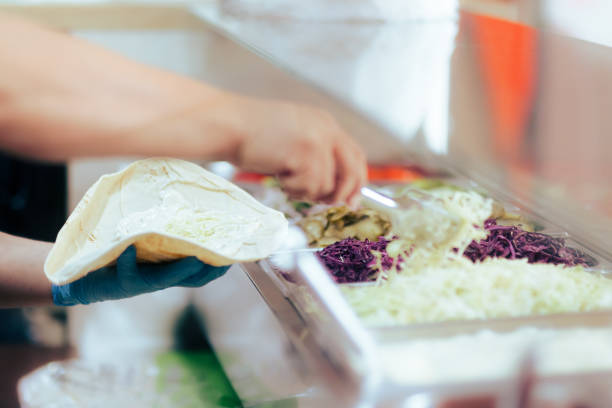 istock Fast Food Chef Putting Cabbage in Pita Wrap Making a Shawarma Dish 1322062321