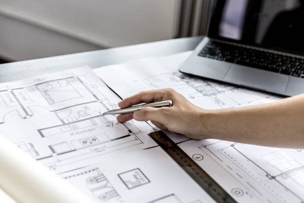 istock Architect engineers are writing house plans in order to modify some of the designs according to the needs of the customers after the proposals are requested to modify the drawings. Interior Design. 1322062392