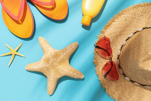 istock Starfish, beach slippers, sun cream, sunglasses and a hat on a blue background 1322065055