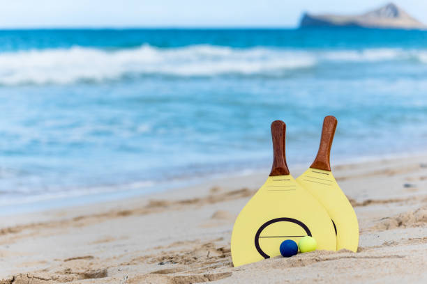 istock Yellow beach paddle and balls on a beach in Hawaii 1322072777