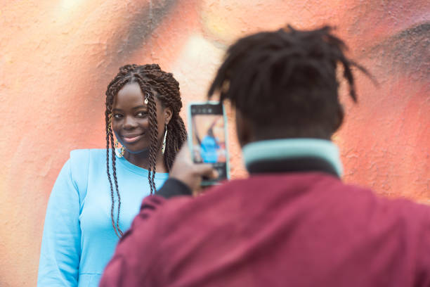 istock Black guy taking a photo with his mobile of his girlfriend. 1322073767