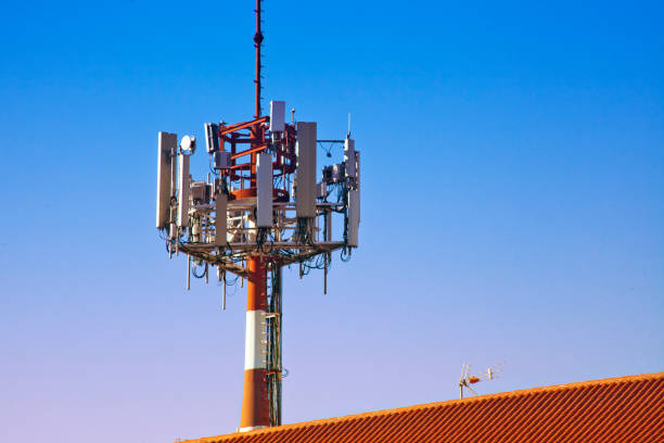 istock Mobile telephony and television relay antennas and building rooftop. 1322080179