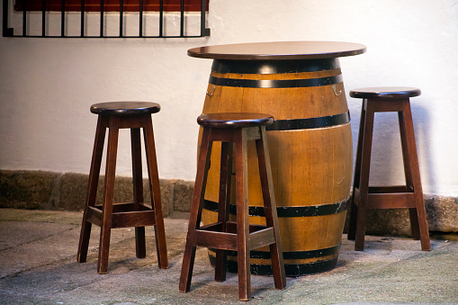 Wine barrel and stools used as sidewalk bar table, pedestrian zone. Vigo city, Pontevedra province, Galicia, Spain.