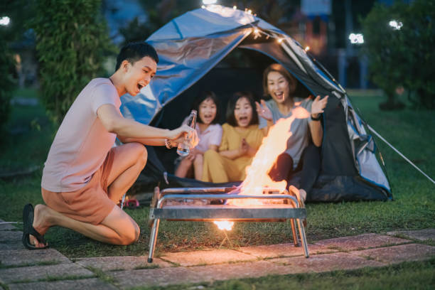istock Asian chinese father using kerosene setting up fire camping at backyard of their house staycation weekend activities 1322081505