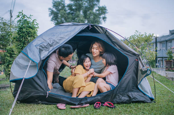 famille chinoise asiatique jouant à l’intérieur de la tente de camping à l’arrière-cour de leur maison staycation activités week-end - camping family tent couple photos et images de collection