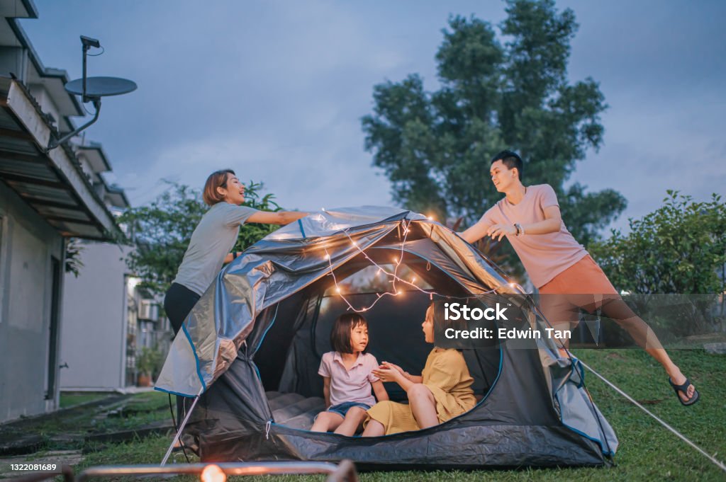 Asian chinese family putting on string light decorating camping at backyard of their house staycation weekend activities Family Stock Photo