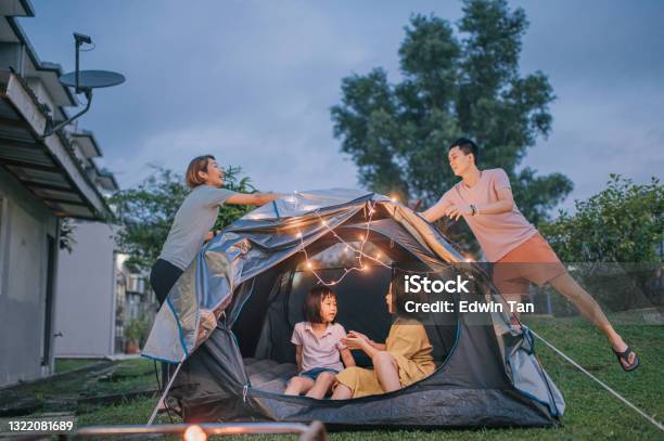 Asian Chinese Family Putting On String Light Decorating Camping At Backyard Of Their House Staycation Weekend Activities Stock Photo - Download Image Now