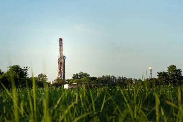 Photo of Onshore oil drilling rig platform on blue sky - Petroleum exploration industrial.