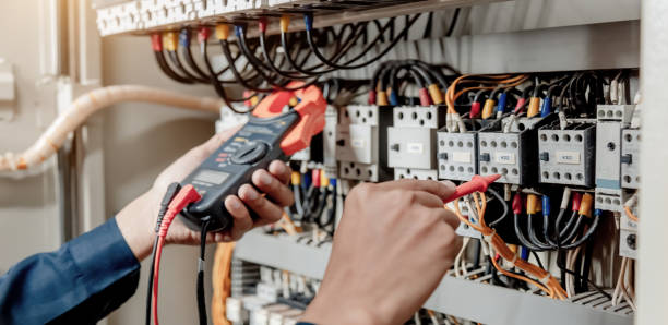 istock Electrician engineer uses a multimeter to test the electrical installation and power line current in an electrical system control cabinet. 1322083359